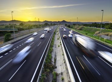 Busy highway at sunset, vehicles coming and going, city stress -