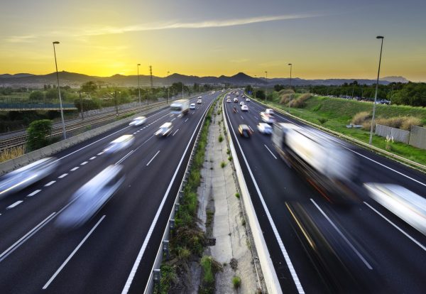 Busy highway at sunset, vehicles coming and going, city stress -